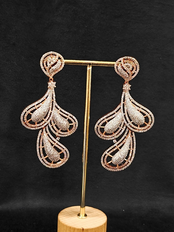 Close-up of an ornate Western American Diamond Rose Gold Earrings with American Diamond. Elegant party wear styled with high-quality imitation American Diamond earrings. Close-up of American diamond earrings styled for a reception party.