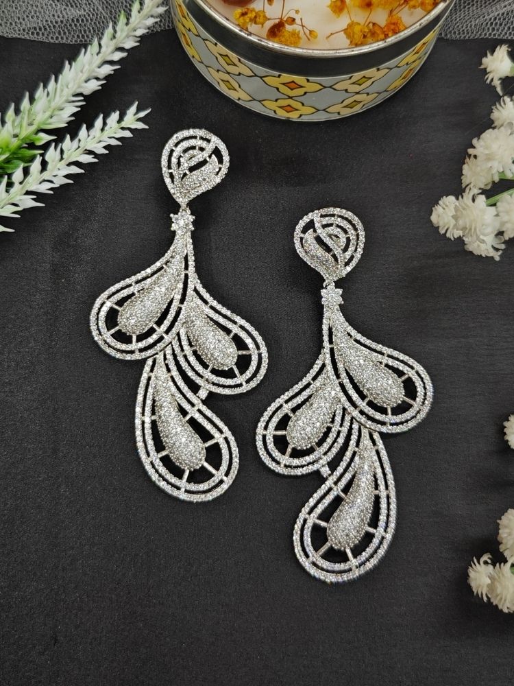 Close-up of an ornate Western American Diamond Silver Earrings with American Diamond. Elegant party wear styled with high-quality imitation American Diamond earrings. Close-up of American diamond earrings styled for a reception party.