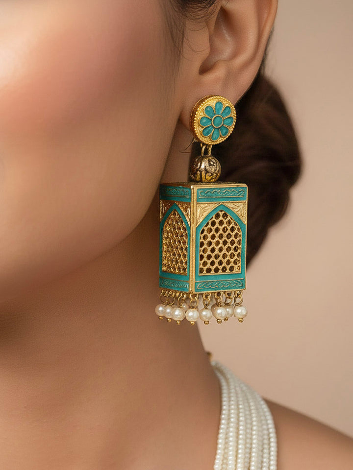 Close-up of a woman wearing an ornate traditional Mint Green Rajwadi gold Long jewellery set and earrings  with  Pearls and Meenakari. Festive Diwali outfit enhanced with a Rajwadi artificial necklace. Woman pairing a Rajwadi necklace with a red saree. Close-up of enamel work in Meenakari artificial wedding jewelry.