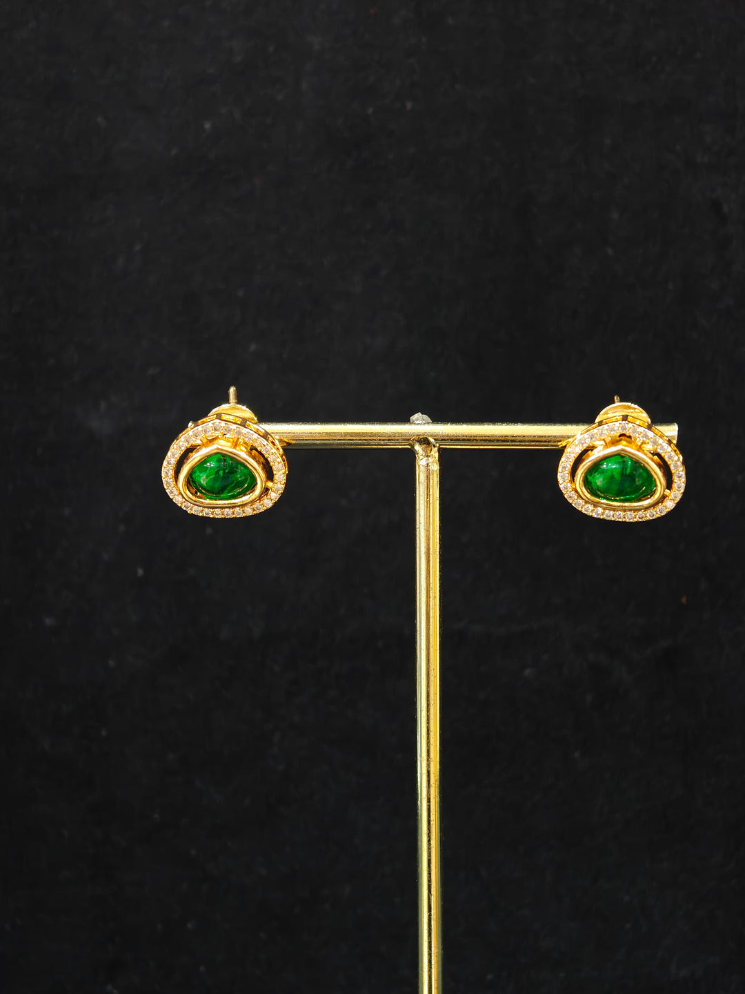 Close-up of an ornate Indo-western Green (Carat Polish) Diamond Pendant set and earrings with American Diamonds, Colored Stones and Moissanite. Elegant festive look with a high-quality imitation American diamond Pendant set. Close-up of high-quality  artificial American Diamond necklace craftsmanship.