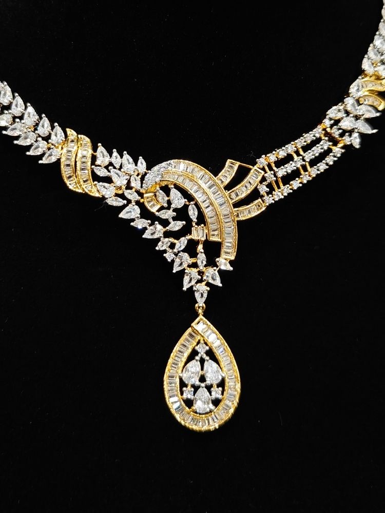 Close-up of an ornate Western (Dual Tone) Gold & Silver Collar jewellery set and earrings with American Diamond. Party wear outfit completed with a lightweight American diamond necklace. Close-up of a cocktail party look featuring a premium American diamond necklace.
