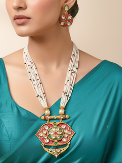 Close-up of a woman wearing an ornate traditional Red Rajwadi gold jewellery set and earrings  with  Kundan, Meenakari, Pearls, Crystal Beads, Ruby Red Colored Stones. Mehendi ceremony look styled with a Rajwadi and Meenakari artificial jewelry set. Model wearing a royal Rajwadi and Meenakari necklace set for festive celebrations in India.