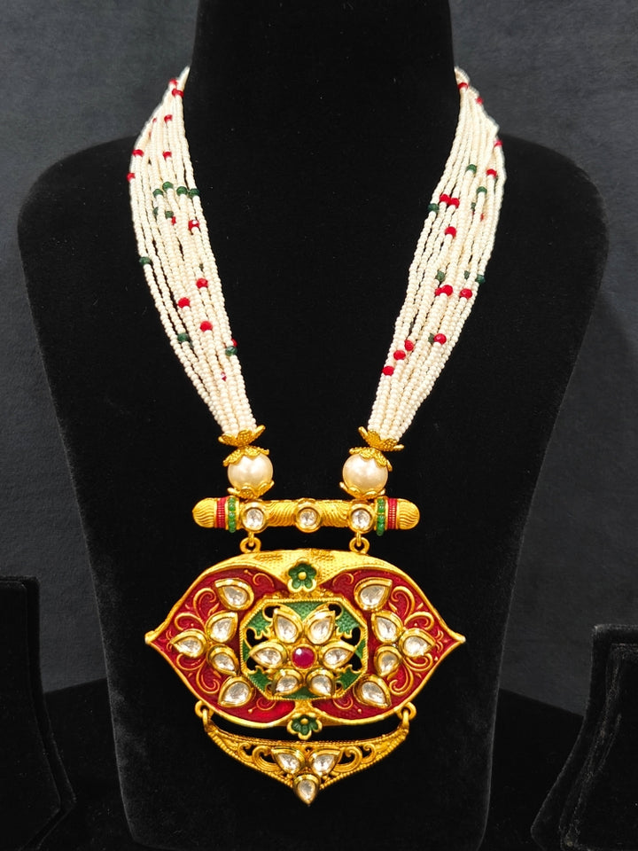Close-up of a woman wearing an ornate traditional Red Rajwadi gold jewellery set and earrings  with  Kundan, Meenakari, Pearls, Crystal Beads, Ruby Red Colored Stones. Mehendi ceremony look styled with a Rajwadi and Meenakari artificial jewelry set. Model wearing a royal Rajwadi and Meenakari necklace set for festive celebrations in India.