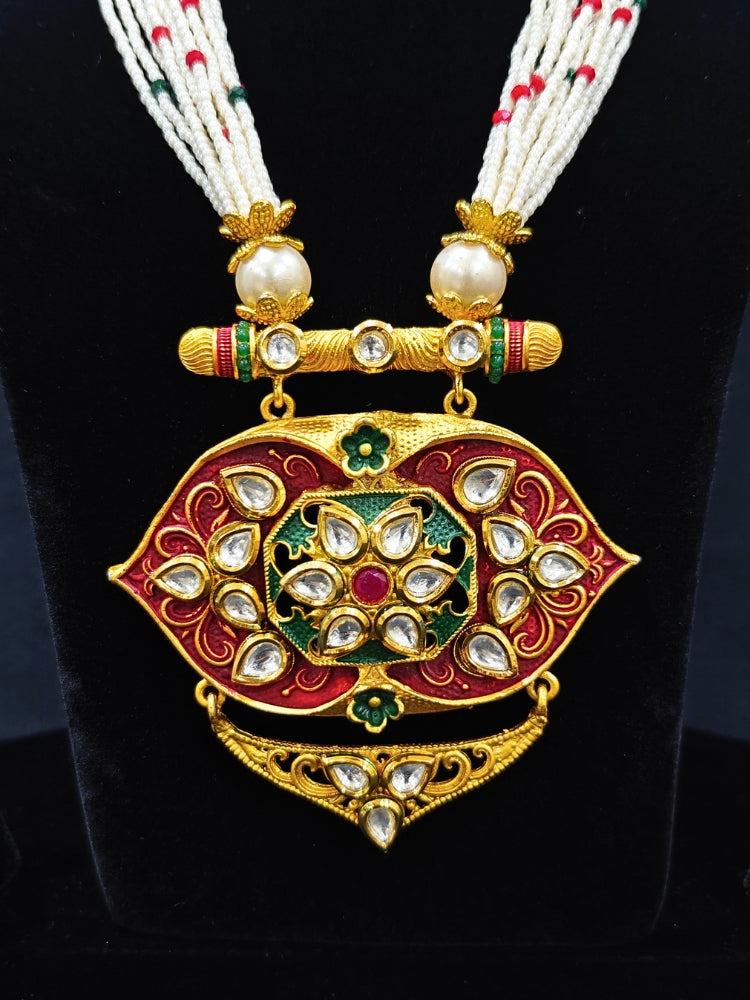 Close-up of a woman wearing an ornate traditional Red Rajwadi gold jewellery set and earrings  with  Kundan, Meenakari, Pearls, Crystal Beads, Ruby Red Colored Stones. Mehendi ceremony look styled with a Rajwadi and Meenakari artificial jewelry set. Model wearing a royal Rajwadi and Meenakari necklace set for festive celebrations in India.