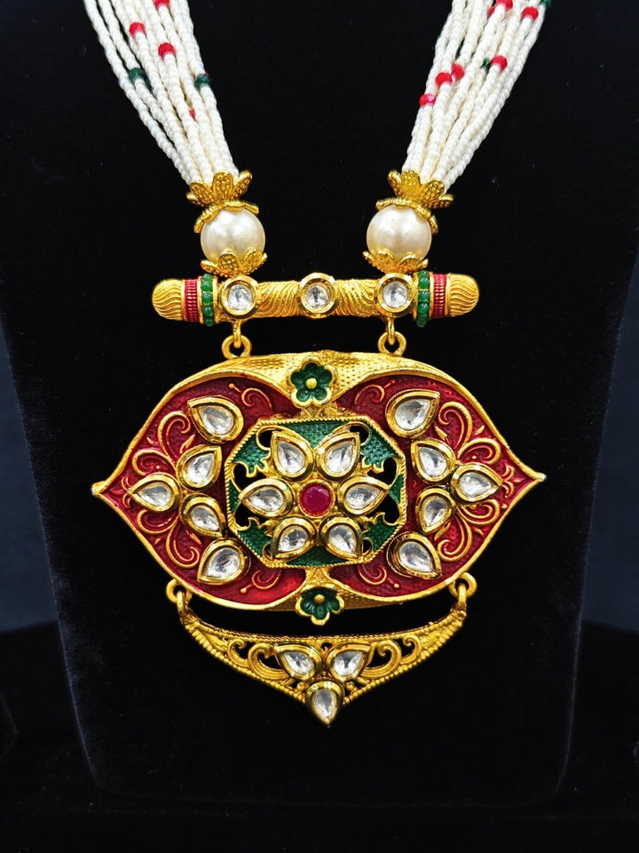 Close-up of a woman wearing an ornate traditional Red Rajwadi gold jewellery set and earrings  with  Kundan, Meenakari, Pearls, Crystal Beads, Ruby Red Colored Stones. Mehendi ceremony look styled with a Rajwadi and Meenakari artificial jewelry set. Model wearing a royal Rajwadi and Meenakari necklace set for festive celebrations in India.
