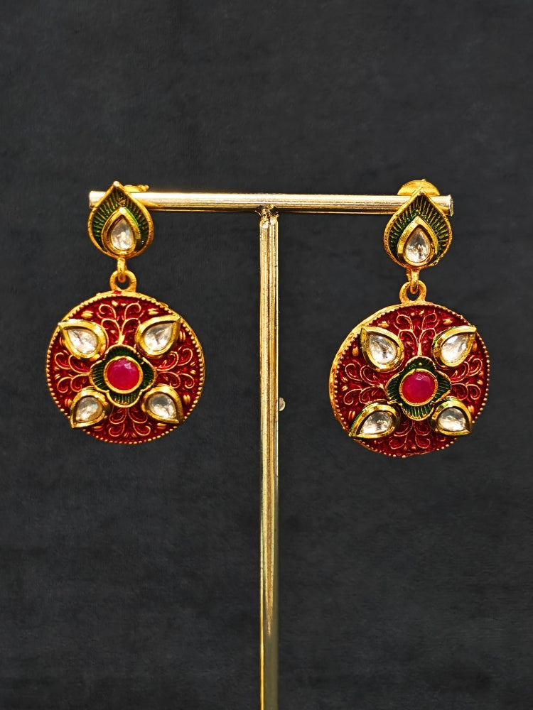 Close-up of a woman wearing an ornate traditional Red Rajwadi gold jewellery set and earrings  with  Kundan, Meenakari, Pearls, Crystal Beads, Ruby Red Colored Stones. Mehendi ceremony look styled with a Rajwadi and Meenakari artificial jewelry set. Model wearing a royal Rajwadi and Meenakari necklace set for festive celebrations in India.