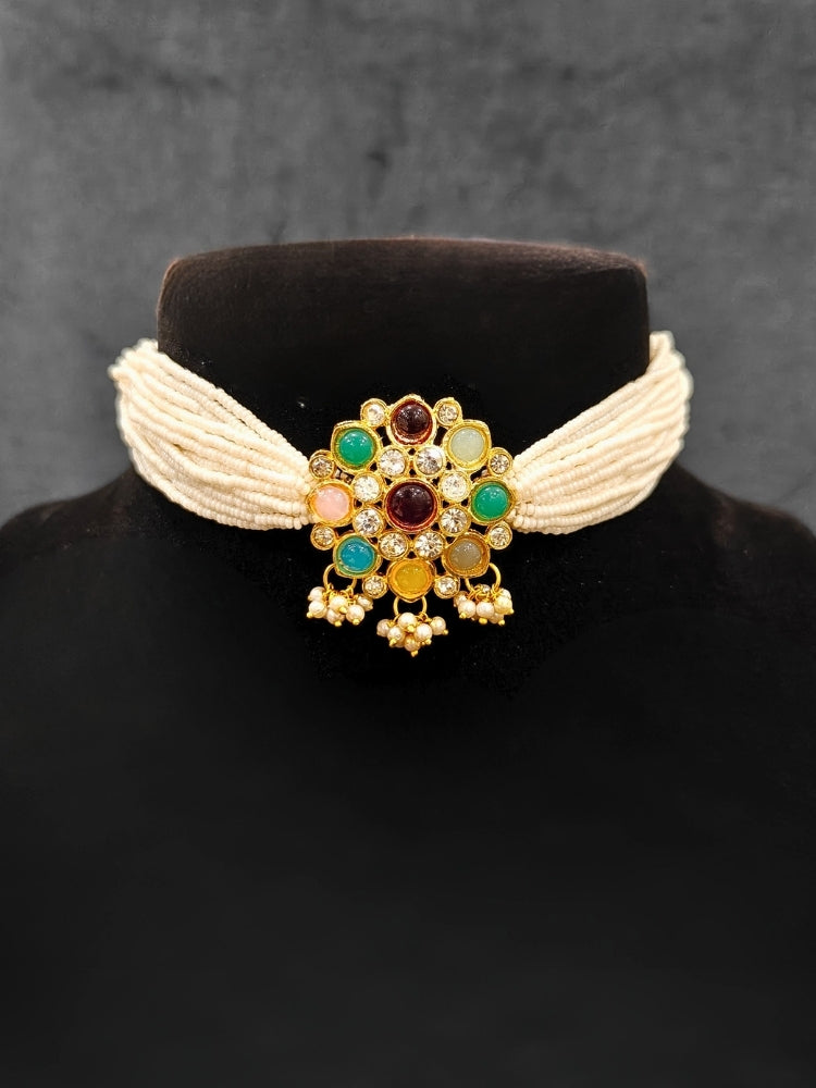 Close-up of an ornate traditional (Gold Polish) Choker jewellery set and earrings with American Damonds,  Multi-Colored Stones and Pearls. Mehendi ceremony look completed with a handcrafted Colored Stone jewelry set. Festive Diwali outfit paired with a colorful  Colored Stones necklace.