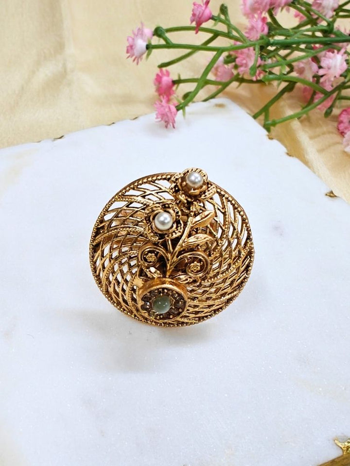 Close-up of an ornate traditional (Gold Polish) Mint Green Ring with Pearl and Mint Green Colored Stone. Bridal mehendi outfit paired with a luxury artificial ring. Festive Diwali look completed with a bold artificial ring.