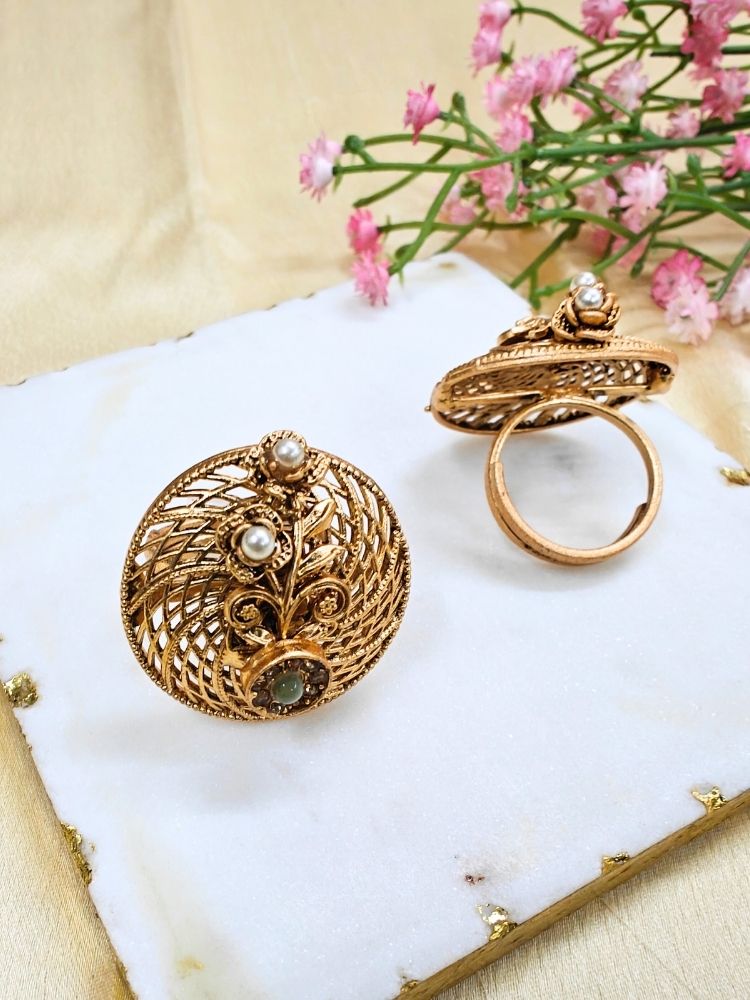 Close-up of an ornate traditional (Gold Polish) Mint Green Ring with Pearl and Mint Green Colored Stone. Bridal mehendi outfit paired with a luxury artificial ring. Festive Diwali look completed with a bold artificial ring.
