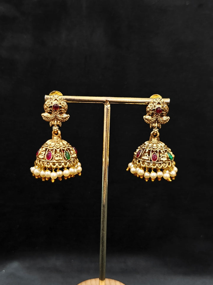 The Kamakshi Temple Necklace Set featuring a traditional gold Long necklace and matching earrings with Goddess Laxmi in the middle, along with pink and green colored stones and pearls, Perfect Temple necklace set for weddings and festivals.
