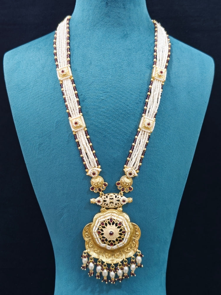 Close-up of an ornate traditional Purple Rajwadi gold Long jewellery set and earrings with Pearls, Crystal beads, American Diamonds, Colored Stones and Meenakari work.  Elegant Anarkali look paired with a traditional Rajwadi artificial necklace. Wedding guest styling a Rajwadi artificial necklace. 