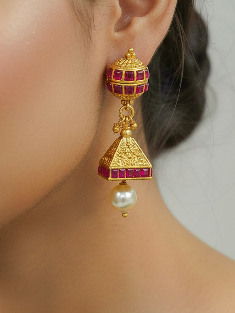 Close-up of a woman wearing an ornate traditional (Gold Polish) Long jewellery set and earrings with Pearls and Colored Stone. Mehendi function outfit styled with a lightweight Pearl necklace. Woman pairing a traditional Pearl necklace with a silk saree.