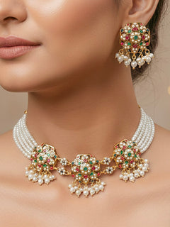 Close-up of a woman wearing an ornate traditional Navratan Choker jadau gold jewellery set and  jadau earrings with Pearl and Navratan Colored Stone. Mehendi function outfit styled with a lightweight Jadau necklace. Festive celebration look featuring a Jadau artificial necklace.