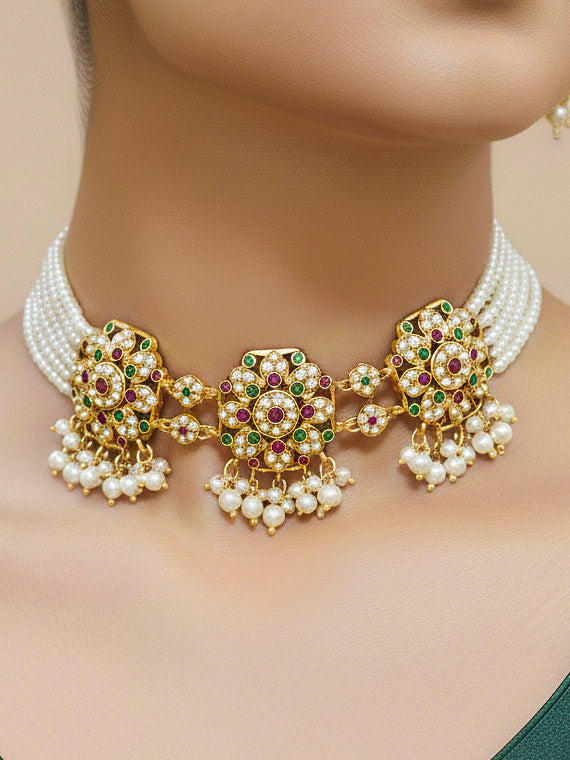 Close-up of a woman wearing an ornate traditional Ruby Pink and Green Choker jadau gold jewellery set and  jadau earrings with Pearl and Colored Stone. Mehendi function outfit styled with a lightweight Jadau necklace. Festive celebration look featuring a Jadau artificial necklace.