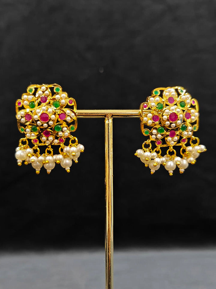 Close-up of an ornate traditional Ruby Pink and Green Choker jadau gold jewellery set and  jadau earrings with Pearl and Colored Stone. Festive look completed with a handcrafted Jadau necklace. A royal Jadau necklace for festive events in India.