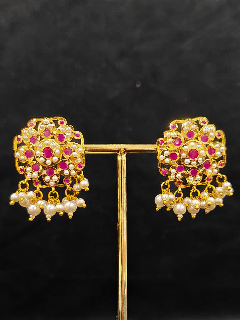 Close-up of an ornate traditional Ruby Pink Choker jadau gold jewellery set and  jadau earrings with Pearl and Colored Stone. Close-up of high-quality Jadau artificial necklace craftsmanship. Close-up of intricate Jadau detailing in artificial jewelry.
