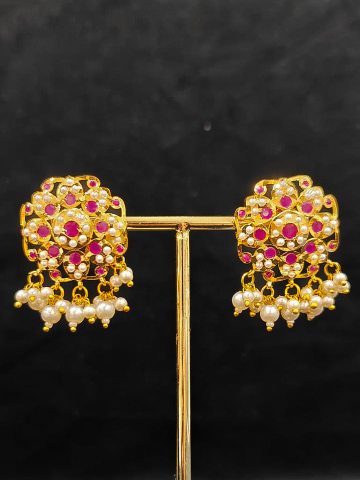 Close-up of an ornate traditional Ruby Pink Choker jadau gold jewellery set and  jadau earrings with Pearl and Colored Stone. Close-up of high-quality Jadau artificial necklace craftsmanship. Close-up of intricate Jadau detailing in artificial jewelry.