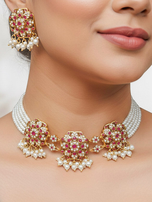 Close-up of a woman wearing an ornate traditional jadau gold jewellery set and jadau earrings with pearls and gemstones. Perfect Jadau necklace set for weddings and festivals. 
