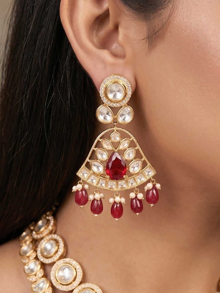 Close-up of a woman wearing an ornate traditional (Gold Polish) Layered Multi-Color jewellery set and earrings with Polki, American Diamond, Colored Stones and Tumble Beads. Woman styling a premium Polki imitation necklace for wedding celebrations. Festive celebration look completed with premium imitation Polki jewelry.