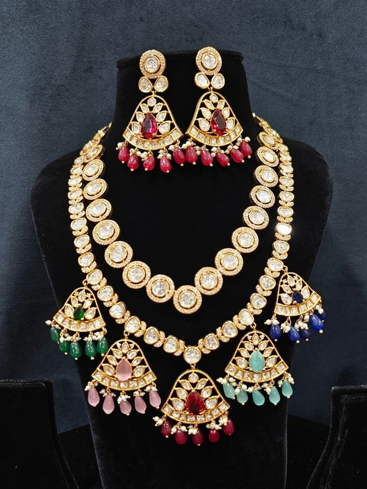 Close-up of an ornate traditional (Gold Polish) Layered Multi-Color jewellery set and earrings with Polki, American Diamond, Colored Stones and Tumble Beads. Woman styling a premium Polki imitation necklace for wedding celebrations. Festive celebration look completed with premium imitation Polki jewelry.