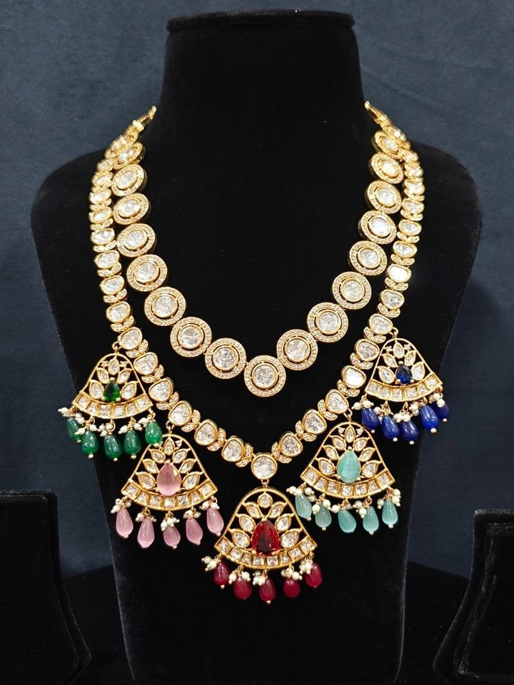 Close-up of an ornate traditional (Gold Polish) Layered Multi-Color jewellery set and earrings with Polki, American Diamond, Colored Stones and Tumble Beads. Woman styling a premium Polki imitation necklace for wedding celebrations. Festive celebration look completed with premium imitation Polki jewelry.