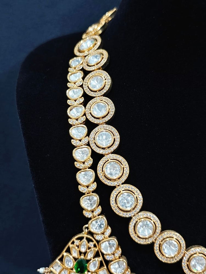 Close-up of an ornate traditional (Gold Polish) Layered Multi-Color jewellery set and earrings with Polki, American Diamond, Colored Stones and Tumble Beads. Woman styling a premium Polki imitation necklace for wedding celebrations. Festive celebration look completed with premium imitation Polki jewelry.