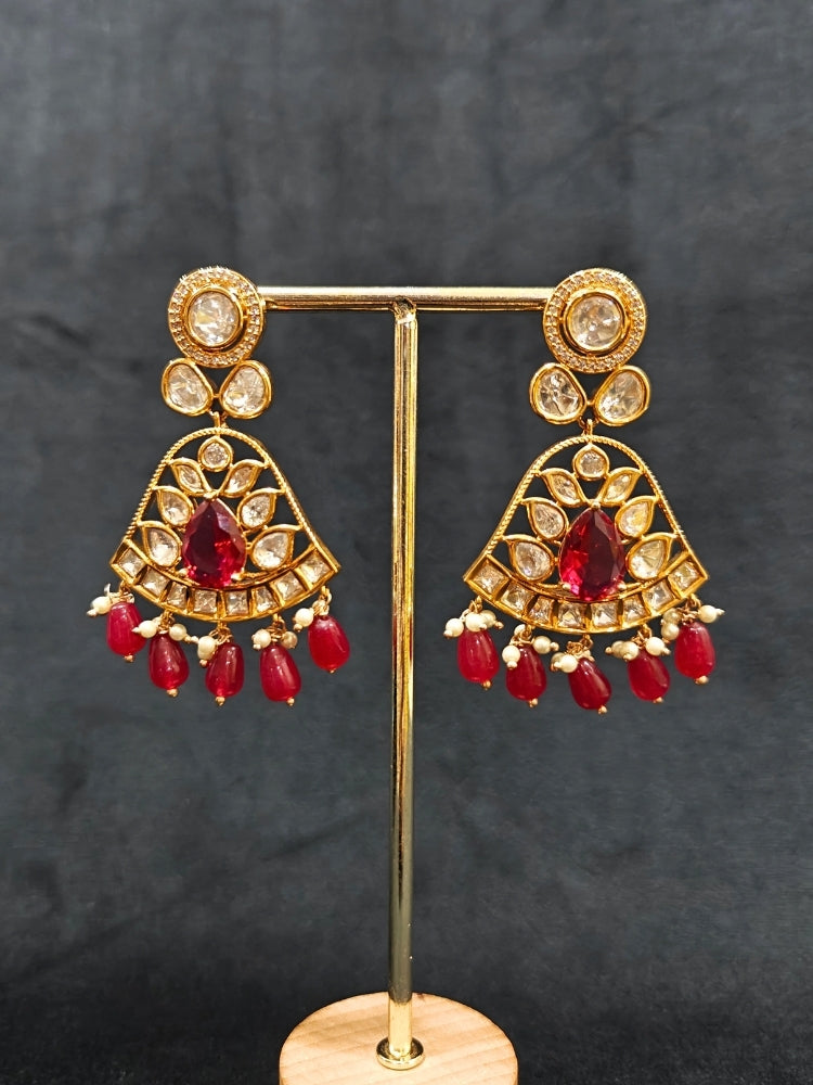 Close-up of an ornate traditional (Gold Polish) Layered Multi-Color jewellery set and earrings with Polki, American Diamond, Colored Stones and Tumble Beads. Woman styling a premium Polki imitation necklace for wedding celebrations. Festive celebration look completed with premium imitation Polki jewelry.