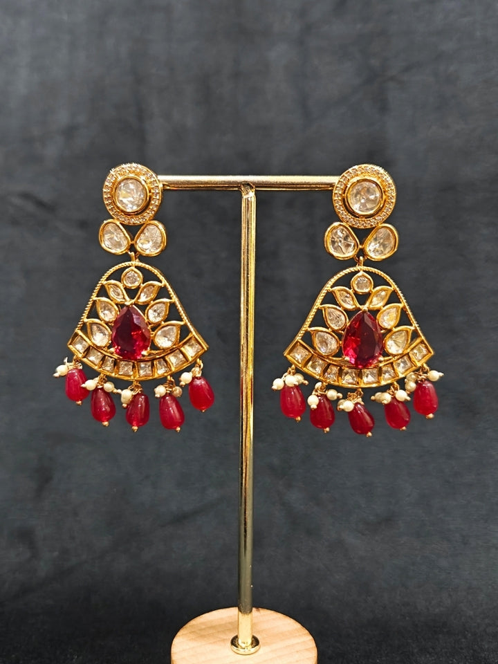 Close-up of an ornate traditional (Gold Polish) Layered Multi-Color jewellery set and earrings with Polki, American Diamond, Colored Stones and Tumble Beads. Woman styling a premium Polki imitation necklace for wedding celebrations. Festive celebration look completed with premium imitation Polki jewelry.