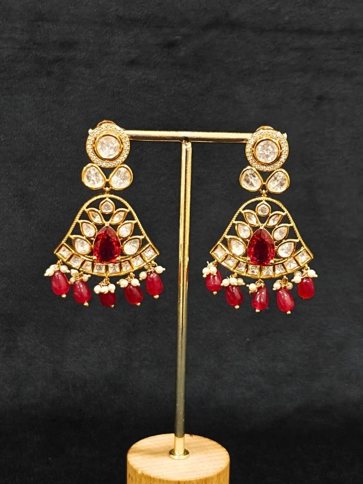 Close-up of an ornate traditional (Gold Polish) Layered Multi-Color jewellery set and earrings with Polki, American Diamond, Colored Stones and Tumble Beads. Woman styling a premium Polki imitation necklace for wedding celebrations. Festive celebration look completed with premium imitation Polki jewelry.