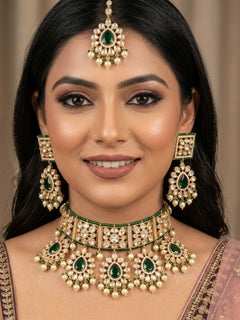 Close-up of a woman wearing an ornate traditional (Gold Polish) Dark Green Choker jewellery set and earrings and maangtikka with Polki, Pearl, Dark Green Colored Stones and Crystal Beads. Woman styling a premium Polki imitation necklace for wedding celebrations. Woman wearing a lightweight Polki jewelry set for long wedding functions.