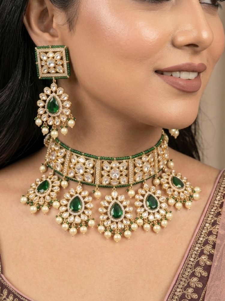 Close-up of a woman wearing an ornate traditional (Gold Polish) Dark Green Choker jewellery set and earrings and maangtikka with Polki, Pearl, Dark Green Colored Stones and Crystal Beads. Woman styling a premium Polki imitation necklace for wedding celebrations. Woman wearing a lightweight Polki jewelry set for long wedding functions.