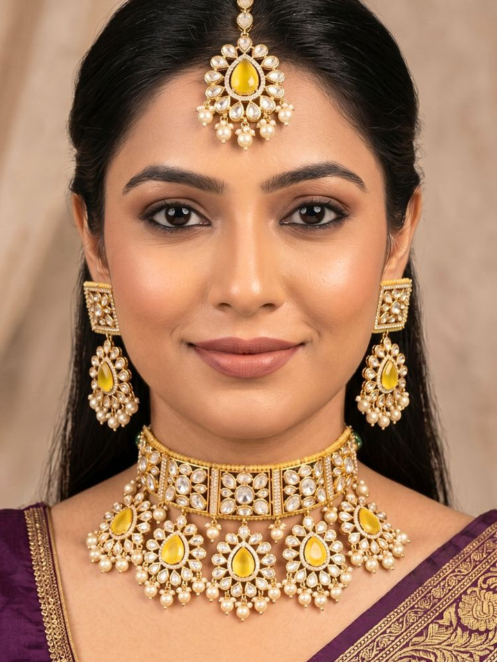 Close-up of a woman wearing an ornate traditional (Gold Polish) Yellow Choker jewellery set and earrings and maangtikka with Polki, Pearl, Yellow Colored Stones and Crystal Beads. Woman styling a premium Polki imitation necklace for wedding celebrations. Woman wearing a lightweight Polki jewelry set for long wedding functions.