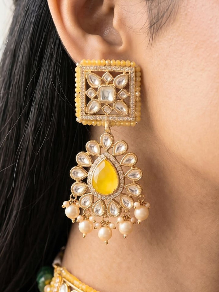 Close-up of a woman wearing an ornate traditional (Gold Polish) Yellow Choker jewellery set and earrings and maangtikka with Polki, Pearl, Yellow Colored Stones and Crystal Beads. Woman styling a premium Polki imitation necklace for wedding celebrations. Woman wearing a lightweight Polki jewelry set for long wedding functions.