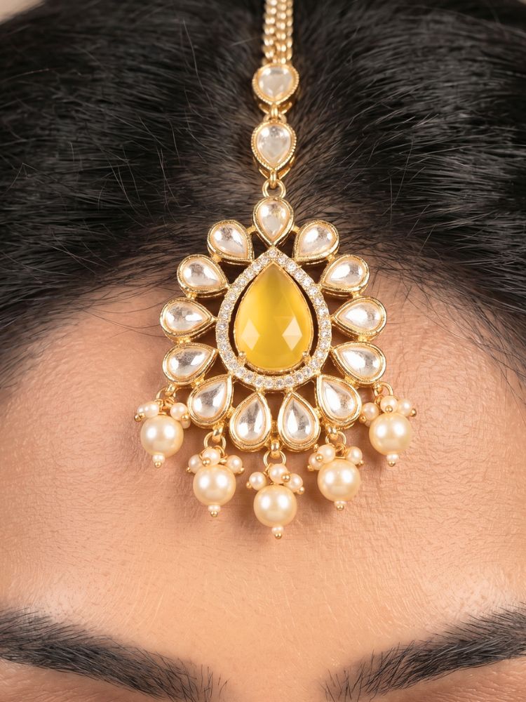 Close-up of a woman wearing an ornate traditional (Gold Polish) Yellow Choker jewellery set and earrings and maangtikka with Polki, Pearl, Yellow Colored Stones and Crystal Beads. Woman styling a premium Polki imitation necklace for wedding celebrations. Woman wearing a lightweight Polki jewelry set for long wedding functions.