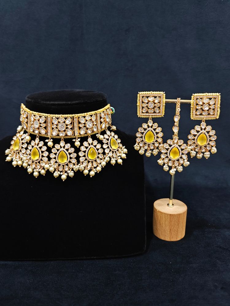 Close-up of an ornate traditional (Gold Polish) Yellow Choker jewellery set and earrings and maangtikka with Polki, Pearl, Yellow Colored Stones and Crystal Beads. Woman styling a premium Polki imitation necklace for wedding celebrations. Woman wearing a lightweight Polki jewelry set for long wedding functions.