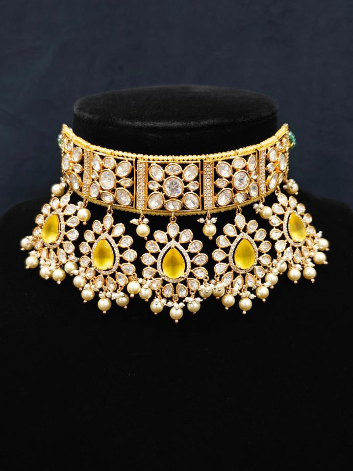 Close-up of an ornate traditional (Gold Polish) Yellow Choker jewellery set and earrings and maangtikka with Polki, Pearl, Yellow Colored Stones and Crystal Beads. Woman styling a premium Polki imitation necklace for wedding celebrations. Woman wearing a lightweight Polki jewelry set for long wedding functions.