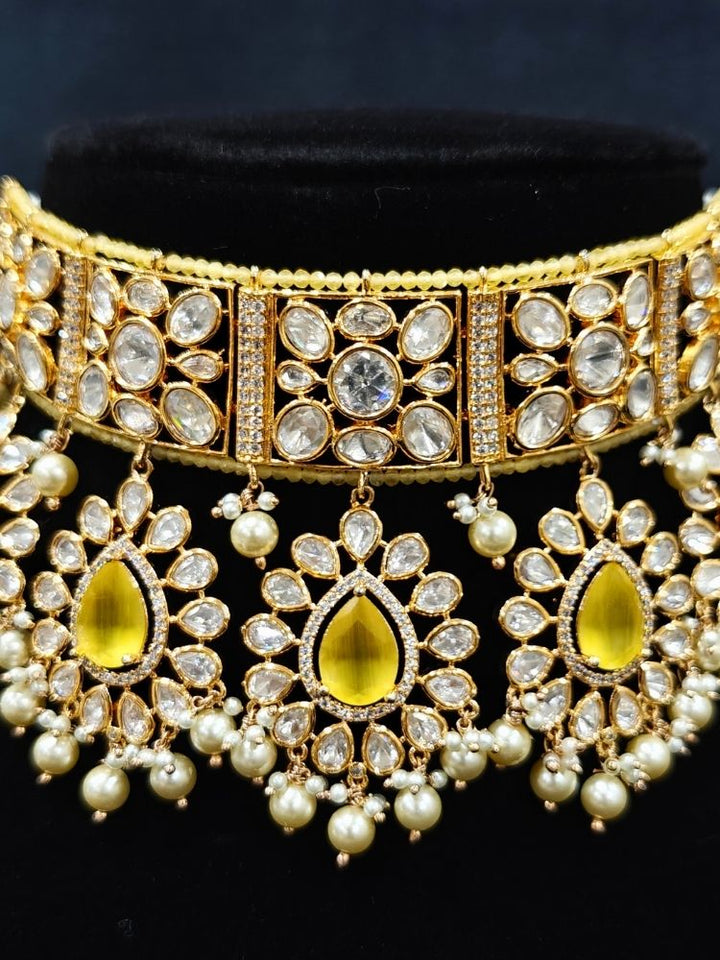 Close-up of an ornate traditional (Gold Polish) Yellow Choker jewellery set and earrings and maangtikka with Polki, Pearl, Yellow Colored Stones and Crystal Beads. Woman styling a premium Polki imitation necklace for wedding celebrations. Woman wearing a lightweight Polki jewelry set for long wedding functions.