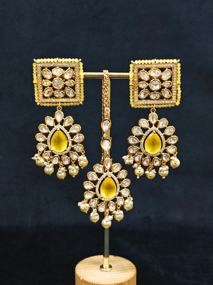 Close-up of an ornate traditional (Gold Polish) Yellow Choker jewellery set and earrings and maangtikka with Polki, Pearl, Yellow Colored Stones and Crystal Beads. Woman styling a premium Polki imitation necklace for wedding celebrations. Woman wearing a lightweight Polki jewelry set for long wedding functions.