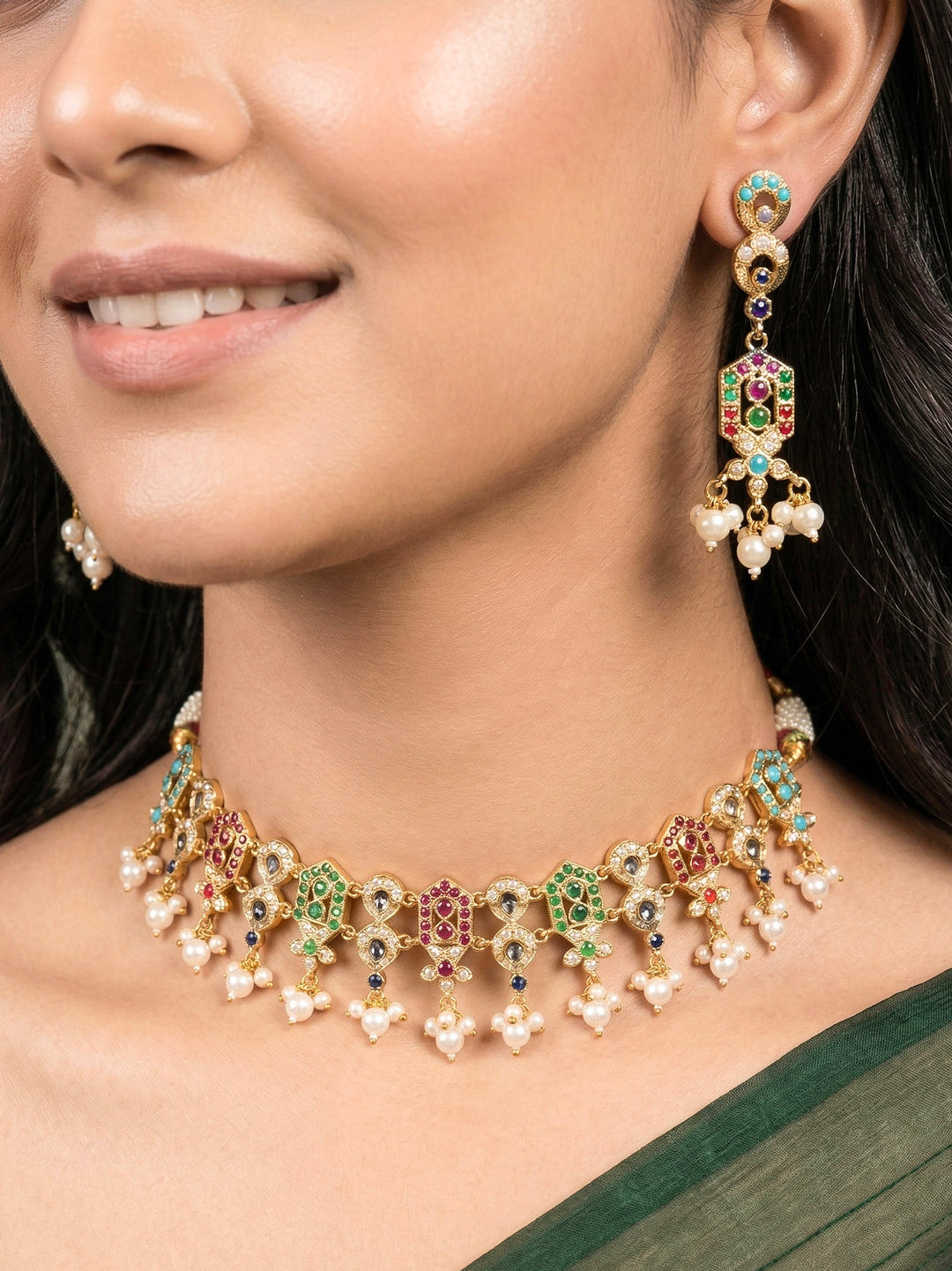 Close-up of a woman wearing an ornate traditional Navratan jadau gold jewellery set and jadau earrings with navratan color stone and Pearls. Woman pairing a traditional Jadau necklace with a silk saree. Woman wearing a royal Jadau necklace for festive events in India.