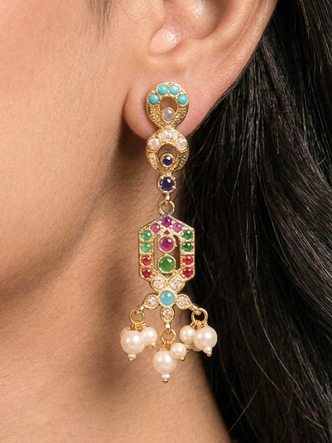 Close-up of a woman wearing an ornate traditional Navratan jadau gold jewellery set and jadau earrings with navratan color stone and Pearls. Woman pairing a traditional Jadau necklace with a silk saree. Woman wearing a royal Jadau necklace for festive events in India.