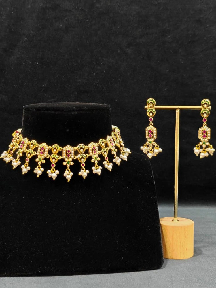 Close-up of a gold Indian traditional jadau jewellery with pearls and ruby pink and green jadau stones. This authentic jadau jewelry set can we worn as jadau necklace set for weddings. a royal Jadau necklace for festive events in India.