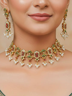 Close-up of a woman wearing an ornate traditional jadau gold jewellery set and jadau earrings with pearls and gemstones. Perfect Jadau necklace set for weddings and festivals. 
