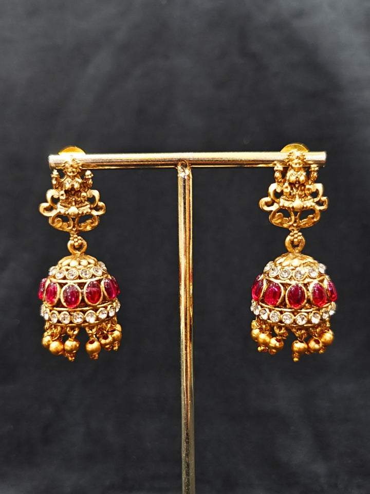 the Red Karuna Temple Necklace Set featuring a traditional gold Long necklace and matching earrings with Red colored stones, paired with a Saree—Saree look enhanced with a royal temple imitation necklace.
