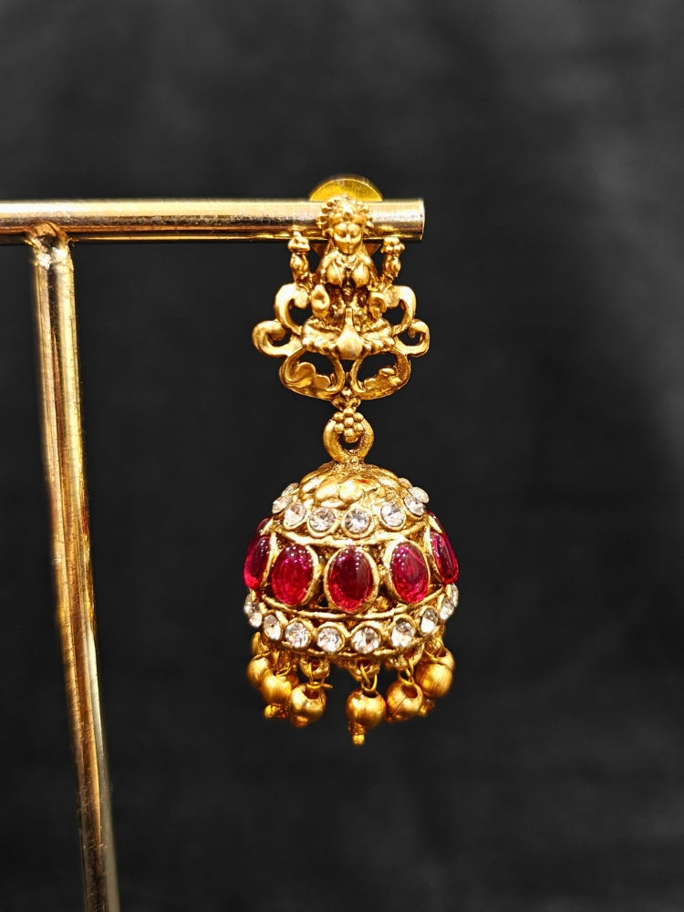 the Red Karuna Temple Necklace Set featuring a traditional gold Long necklace and matching earrings with Red colored stones, paired with a Saree—Saree look enhanced with a royal temple imitation necklace.