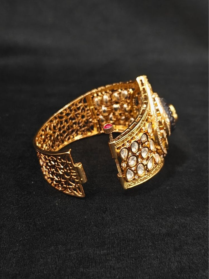 Close-up of an ornate traditional (Gold Polish) Navy Blue Bracelet with Polki, American Diamond and Navy Blue Colored Stone. Close-up of an anti-tarnish artificial Polki bracelet styled for wedding guests.Festive outfit paired with a premium imitation Polki bracelet in India.
