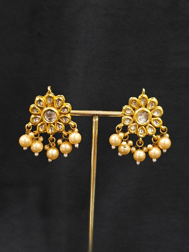 Close-up of an ornate traditional Maroon Layered jewellery set and earrings with Kundan and Beads. Wedding guest wearing a lightweight Kundan necklace for a festive function. Saree look completed with a traditional artificial Kundan set.
