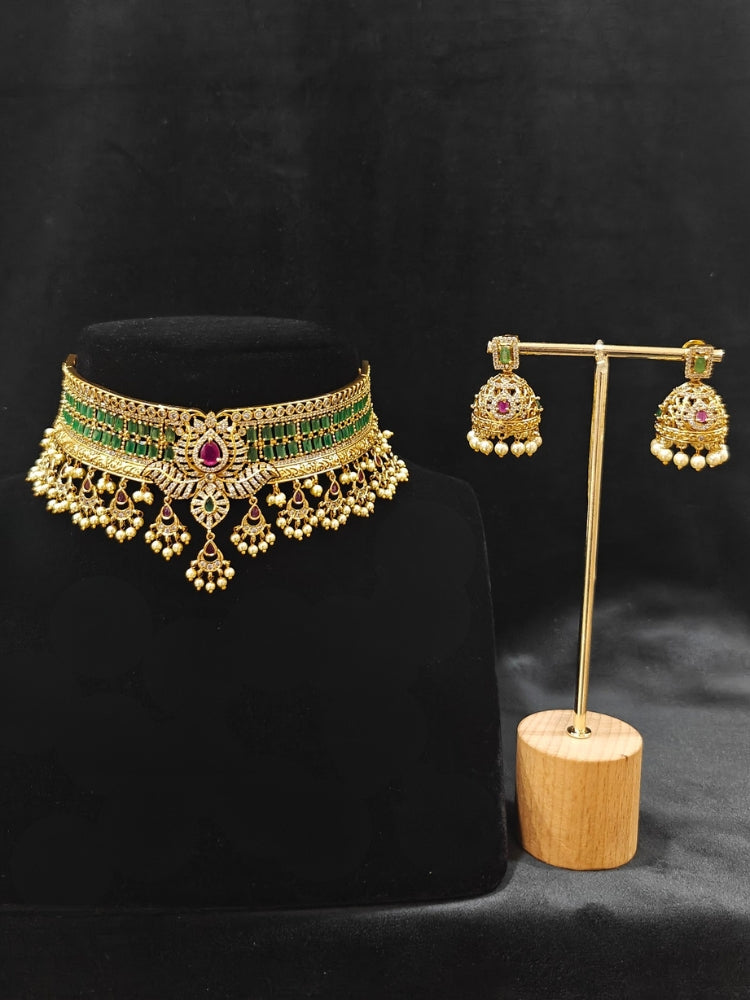 Close-up of an ornate traditional American Diamond gold Green Choker jewellery set and earrings with  Colored Stones, American Diamond and Pearls. Close-up shot of a high-quality American diamond artificial necklace worn for festive celebrations. Bride wearing a sparkling American diamond necklace for her reception night.