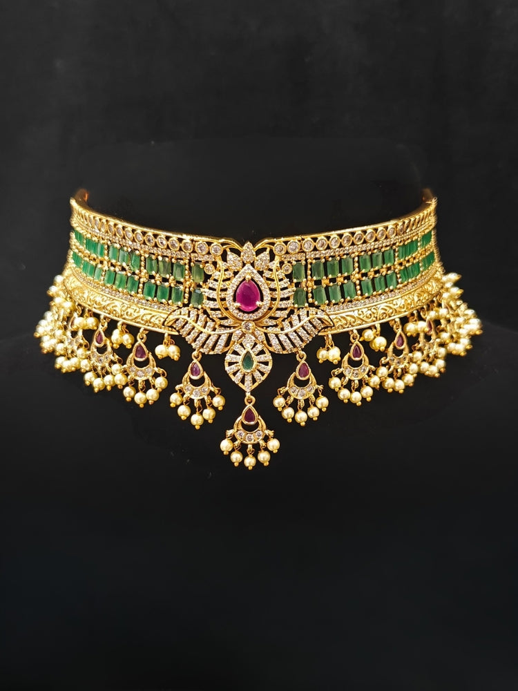 Close-up of an ornate traditional American Diamond gold Green Choker jewellery set and earrings with  Colored Stones, American Diamond and Pearls. Close-up shot of a high-quality American diamond artificial necklace worn for festive celebrations. Bride wearing a sparkling American diamond necklace for her reception night.