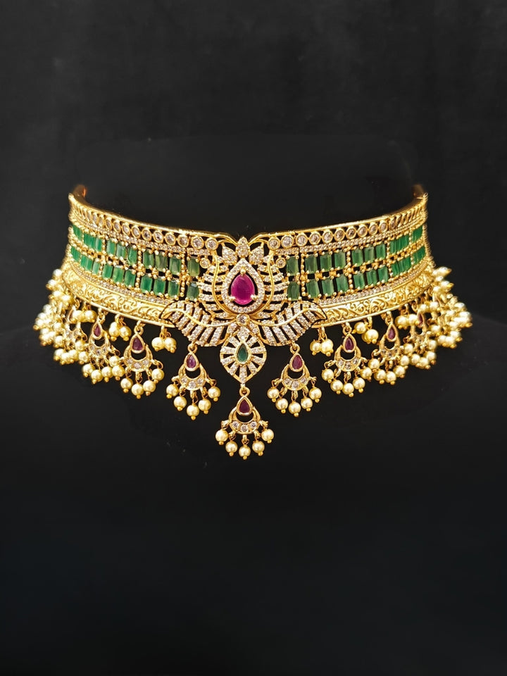 Close-up of an ornate traditional American Diamond gold Green Choker jewellery set and earrings with  Colored Stones, American Diamond and Pearls. Close-up shot of a high-quality American diamond artificial necklace worn for festive celebrations. Bride wearing a sparkling American diamond necklace for her reception night.