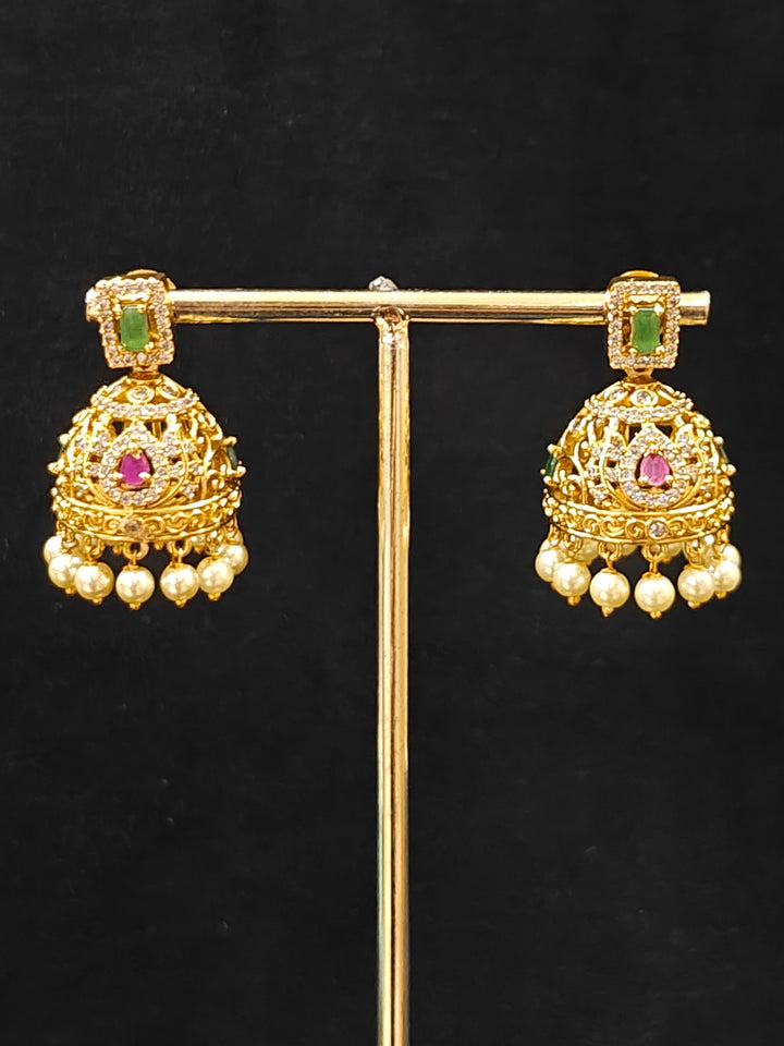 Close-up of an ornate traditional American Diamond gold Green Choker jewellery set and earrings with  Colored Stones, American Diamond and Pearls. Close-up shot of a high-quality American diamond artificial necklace worn for festive celebrations. Bride wearing a sparkling American diamond necklace for her reception night.